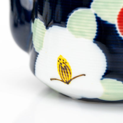 White camellia decoration on the blue teapot's body.
