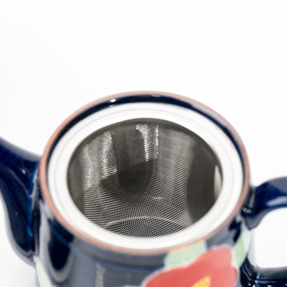 Top view into the blue teapot and its metal mesh strainer.
