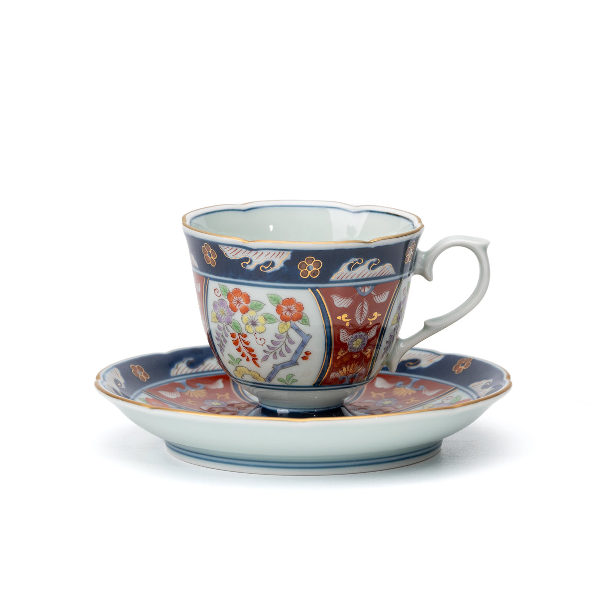 Blue and red Arita cup and saucer with floral panels and gold accents on white.