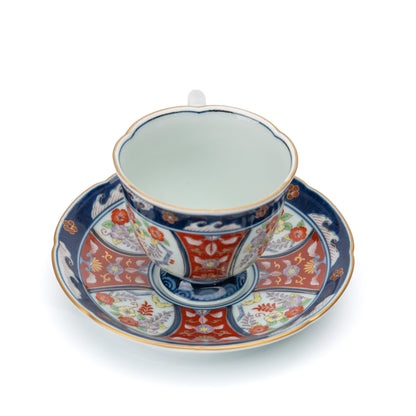 Top view of the cup's white interior on the patterned saucer.