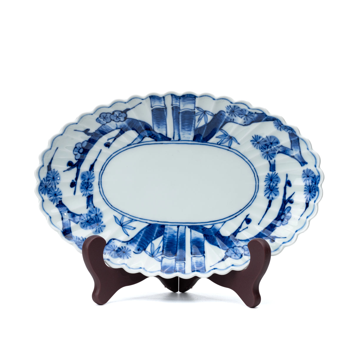 Oval blue and white platter displayed upright on a small stand on white.
