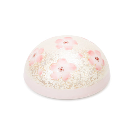 Domed pink cherry blossom lid viewed from above.