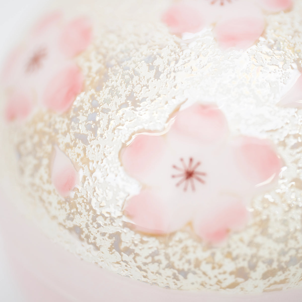 Pink cherry blossom against the lid's fine pale decoration.