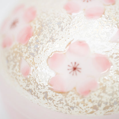 Pink cherry blossom against the lid's fine pale decoration.
