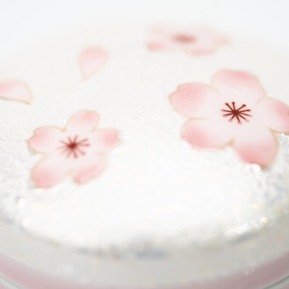 Close-up of pink cherry blossoms across the box lid.