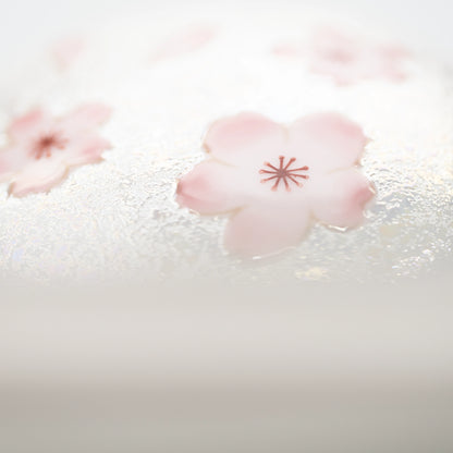 Detail of the lid's rounded edge and pink floral decoration.
