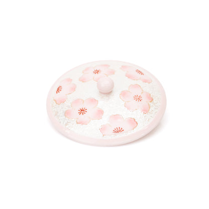 Top view of the pink cherry blossom lid and its rounded knob.