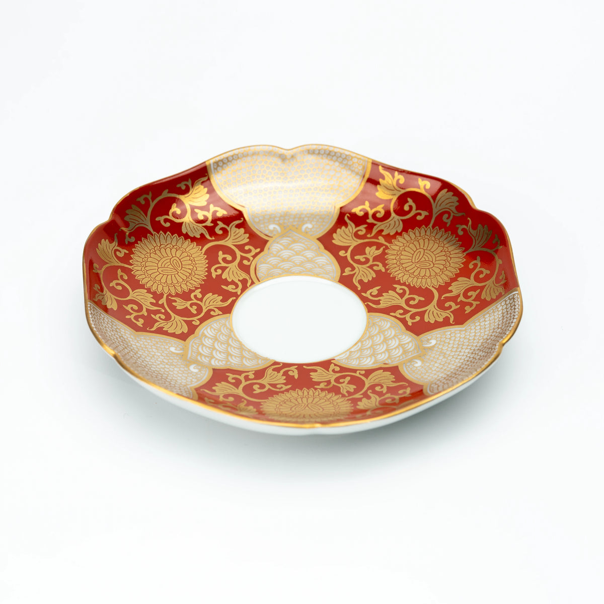 Angled view of the red and gold scalloped saucer.