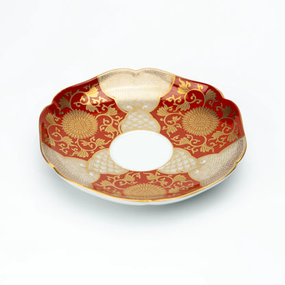 Angled view of the red and gold scalloped saucer.