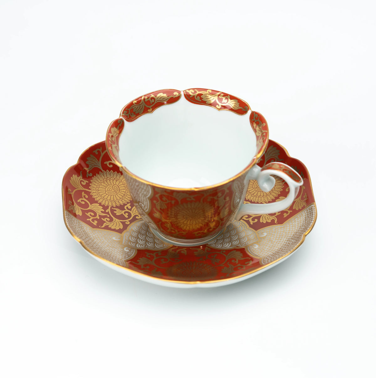 Red and gold chrysanthemum cup and scalloped saucer on white.
