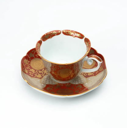 Red and gold chrysanthemum cup and scalloped saucer on white.