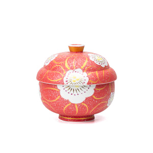 Red porcelain lidded bowl with white flowers and gold scrolls on white.