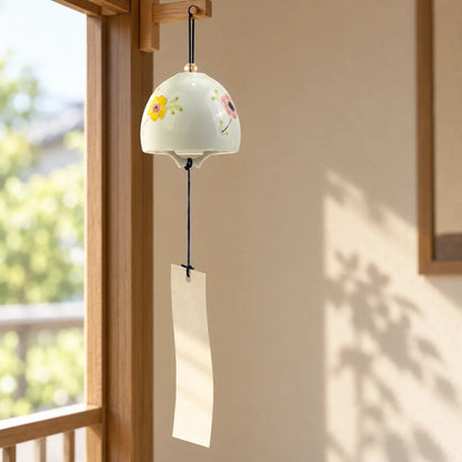 Arita Shikisaika floral porcelain wind chime with paper tanzaku hanging beside an open window