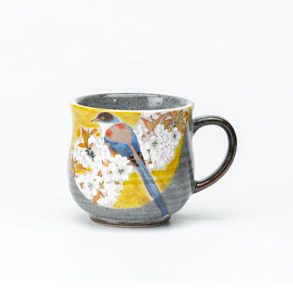 Front view of the yellow Kutani bird and cherry blossom mug.