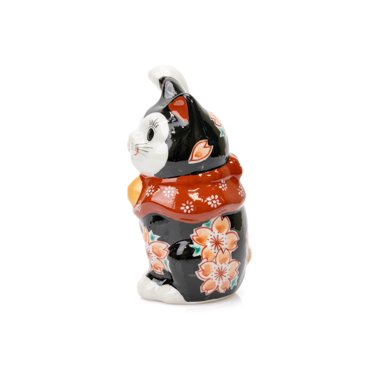 Side view of the black Kutani lucky cat with cherry blossoms and a red floral bib.