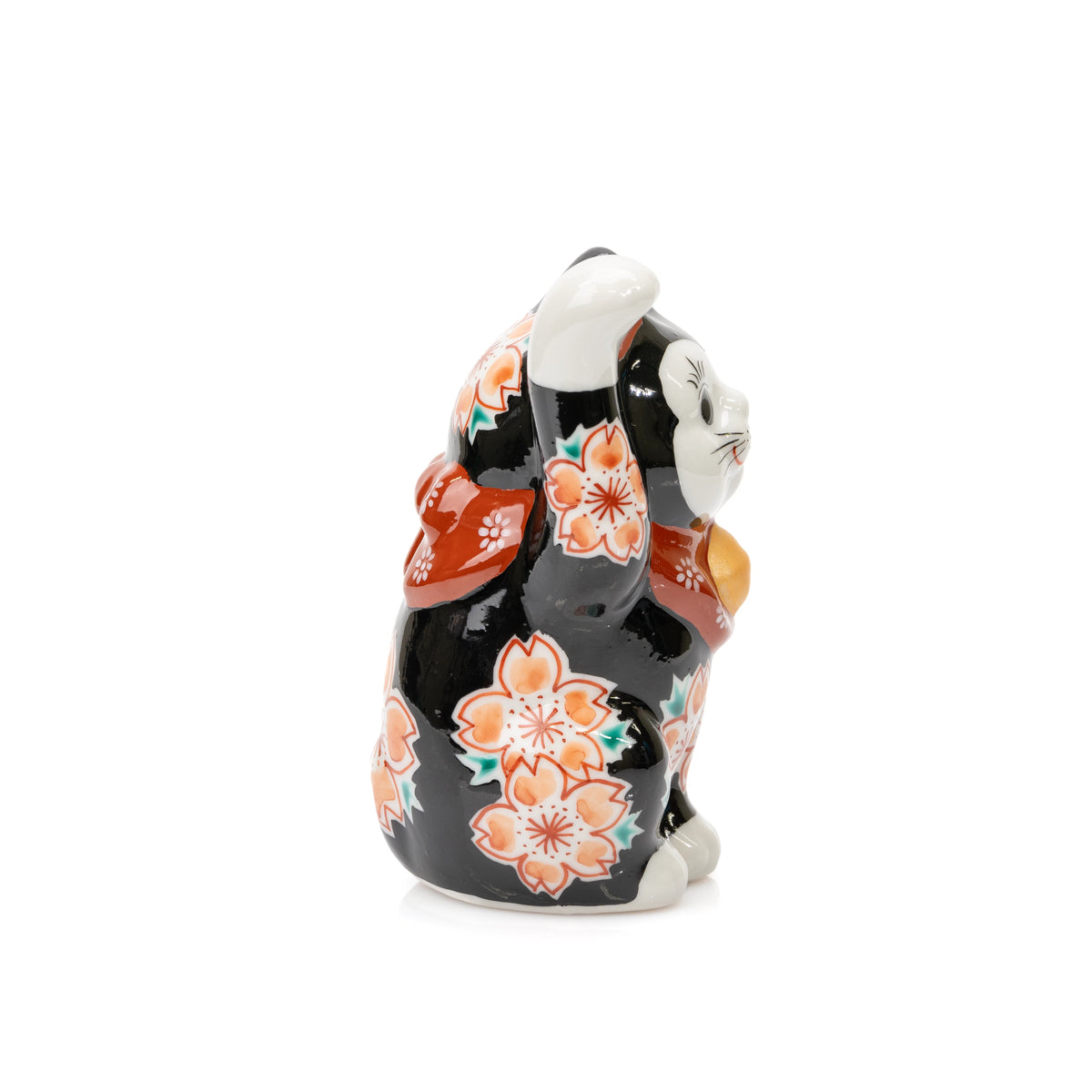 Side view of the raised paw and cherry blossoms on the black Kutani lucky cat.