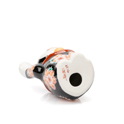 Underside of the black Kutani lucky cat with a red maker's mark and round vent hole.