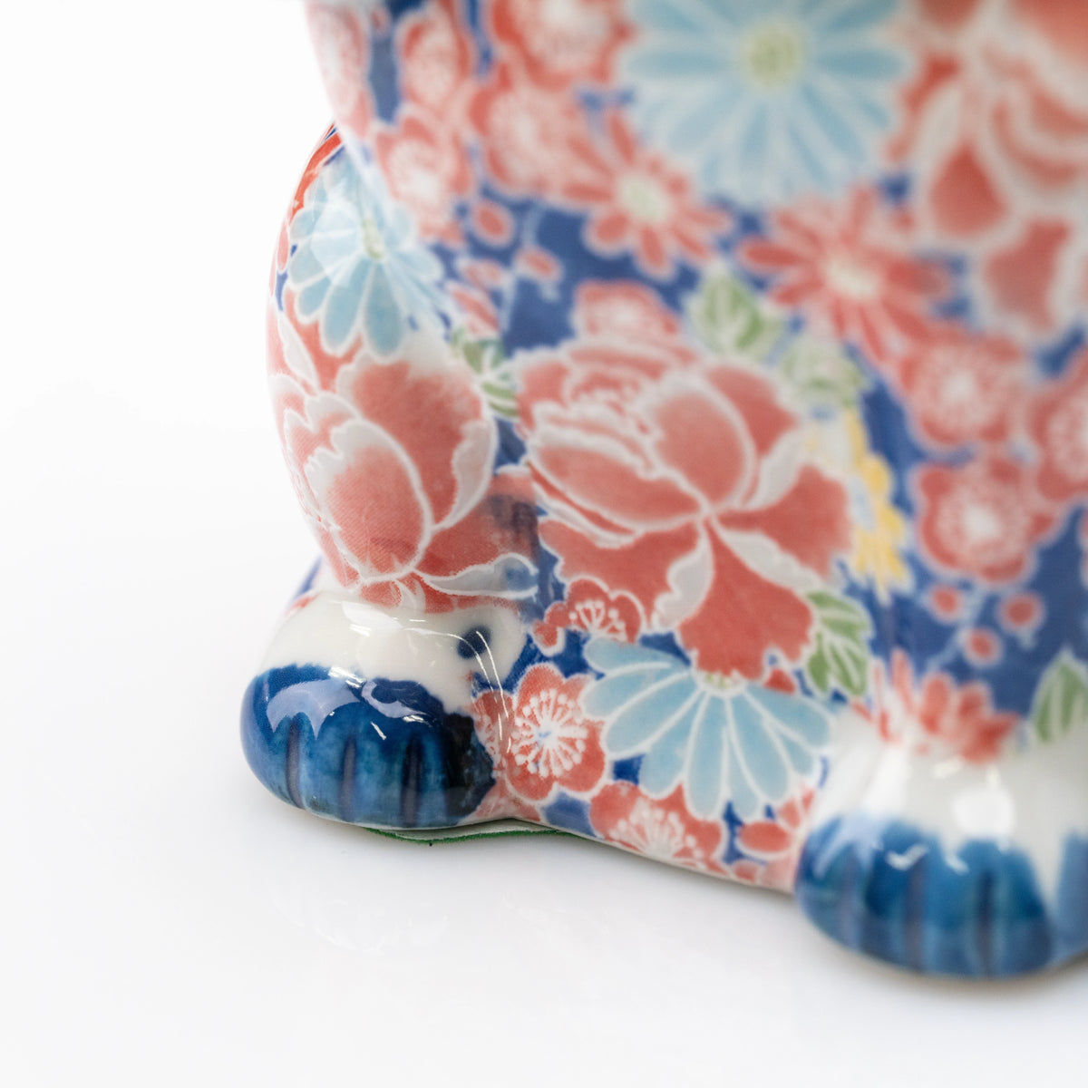 Pink floral decoration above the cat's blue paws.