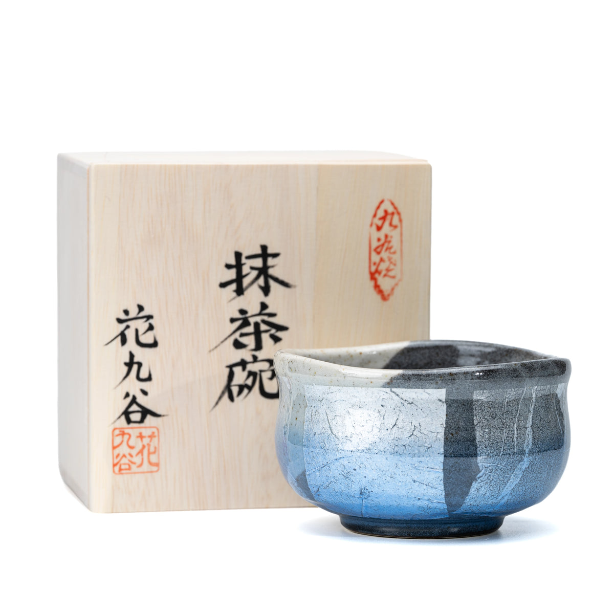 Blue ginsai matcha bowl beside its inscribed wooden presentation box.