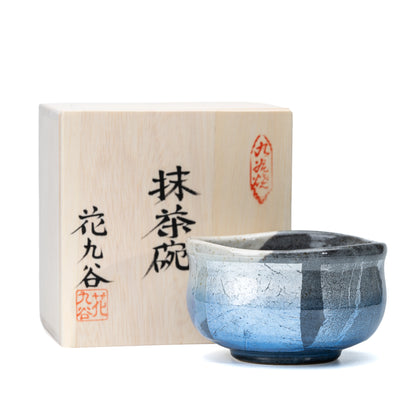Blue ginsai matcha bowl beside its inscribed wooden presentation box.