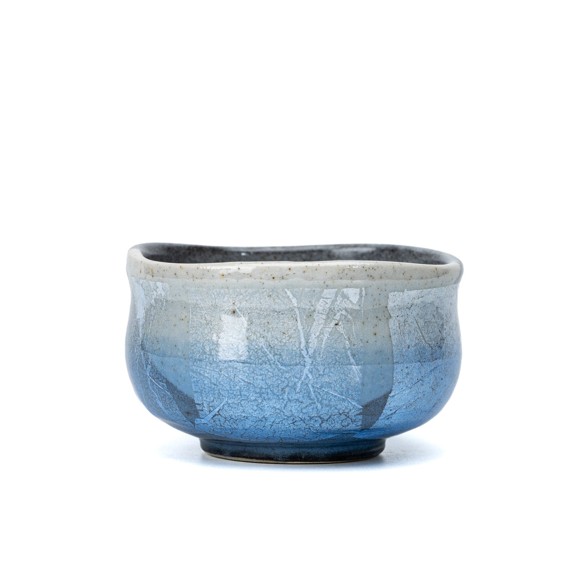 Blue and silver-foil panels around the rounded matcha bowl.