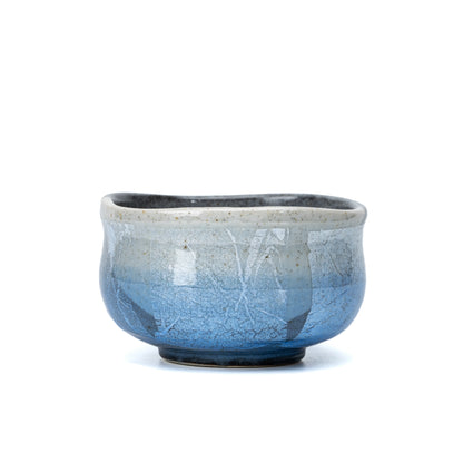 Blue and silver-foil panels around the rounded matcha bowl.