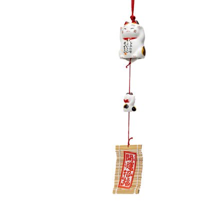 Calico cat wind chime with hanging kitten and red paper strip on white.