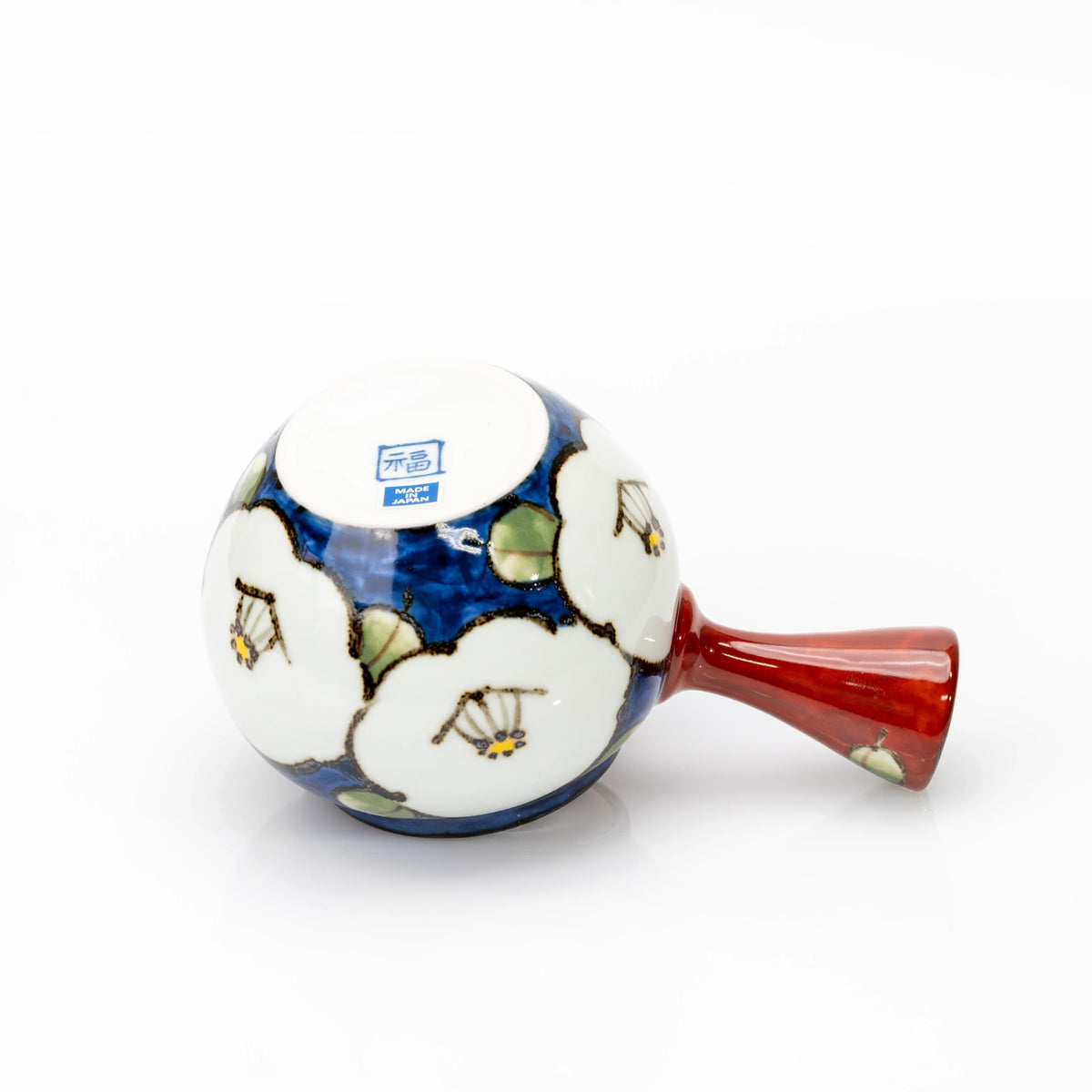 Underside of the blue camellia teapot with a blue square 福 mark, a Made in Japan sticker and red side handle.