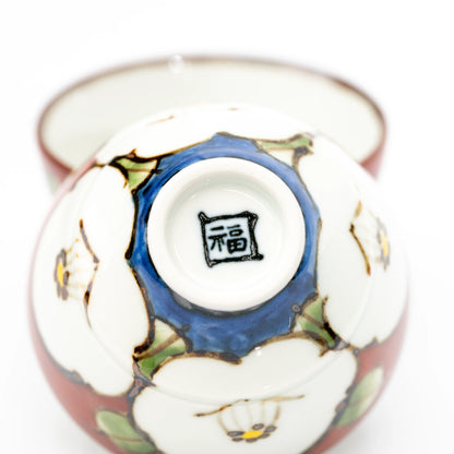 Close-up of the base of a camellia cup, showing a black square 福 mark within the white foot ring.