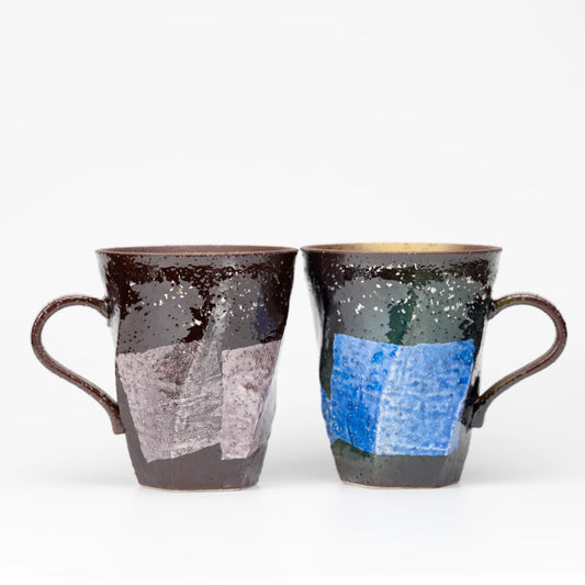 Pair of dark faceted Kutani mugs with blue and lilac silver-foil panels on white.