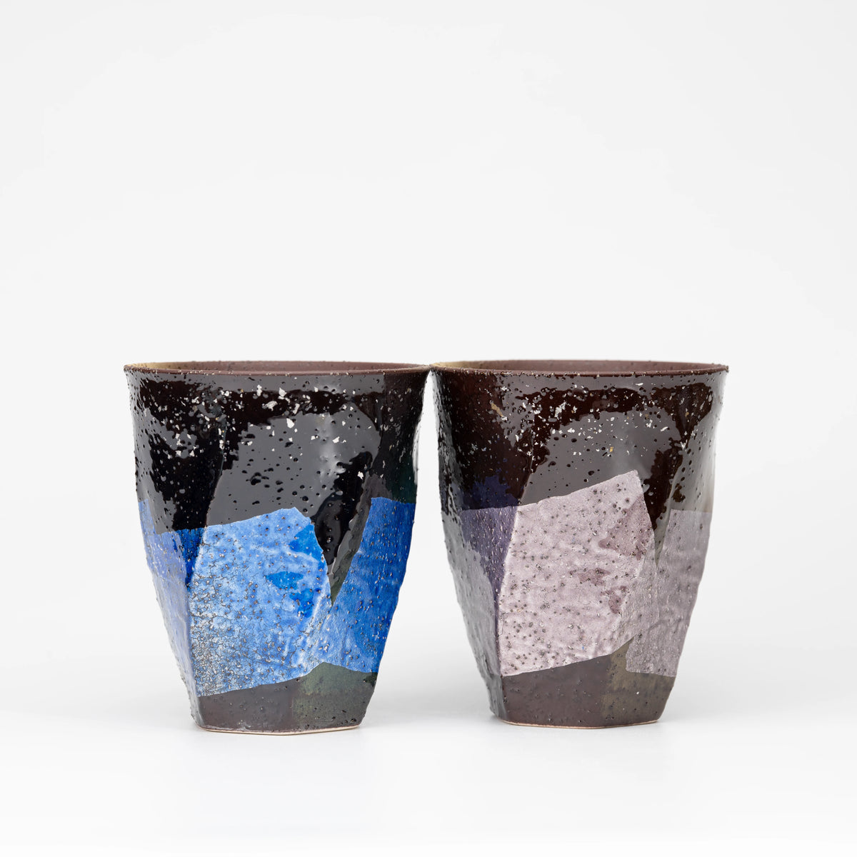 Blue and lilac silver-foil panels across two dark Kutani mugs.