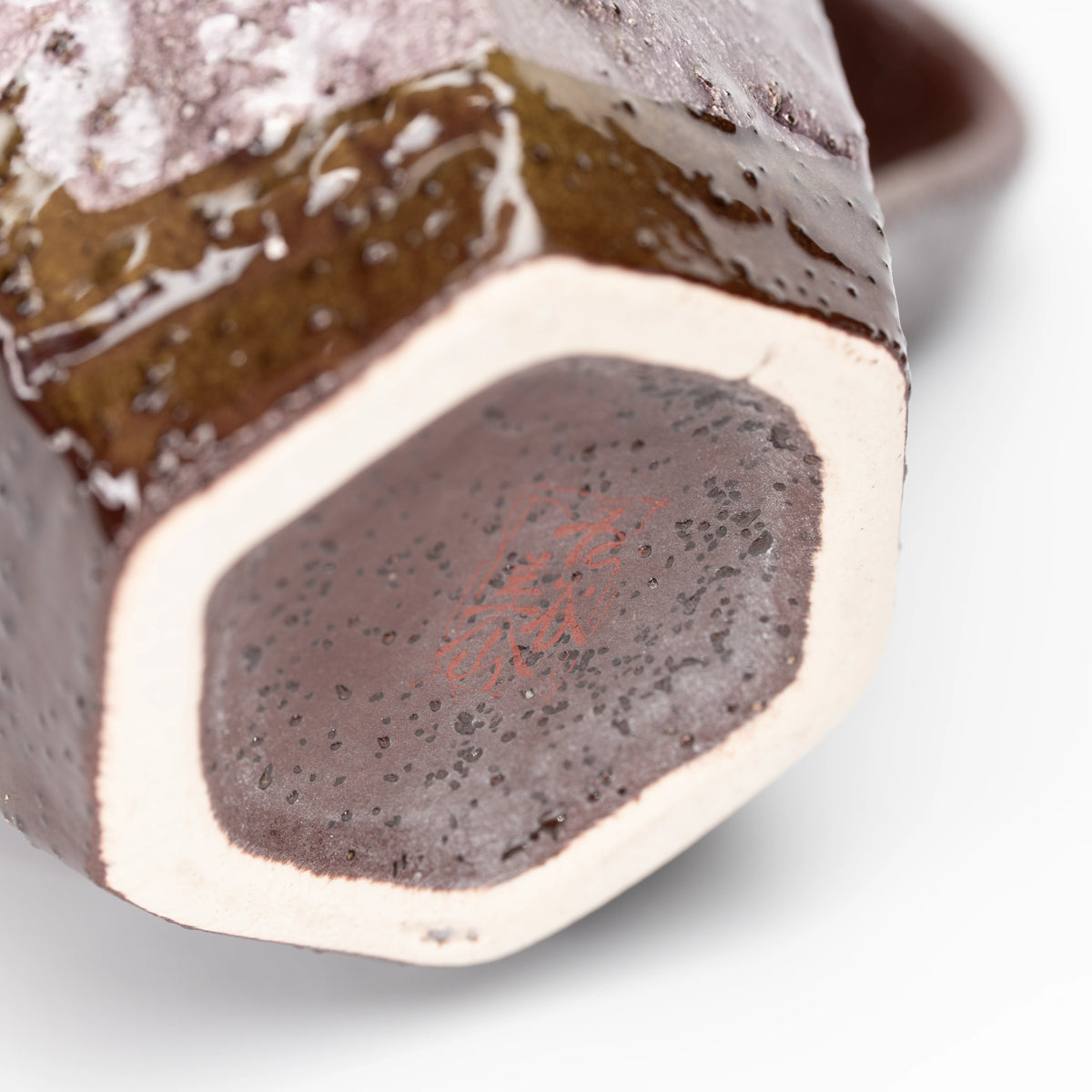 Polygonal unglazed foot and speckled underside of the lilac mug.