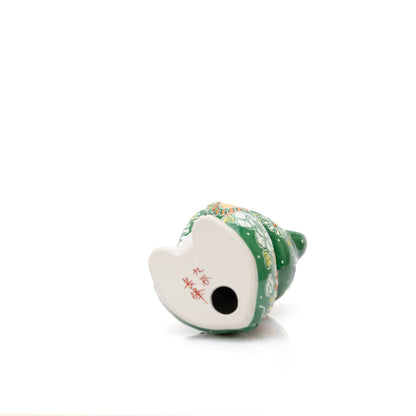 Underside of the green cat with a red inscription and round opening.