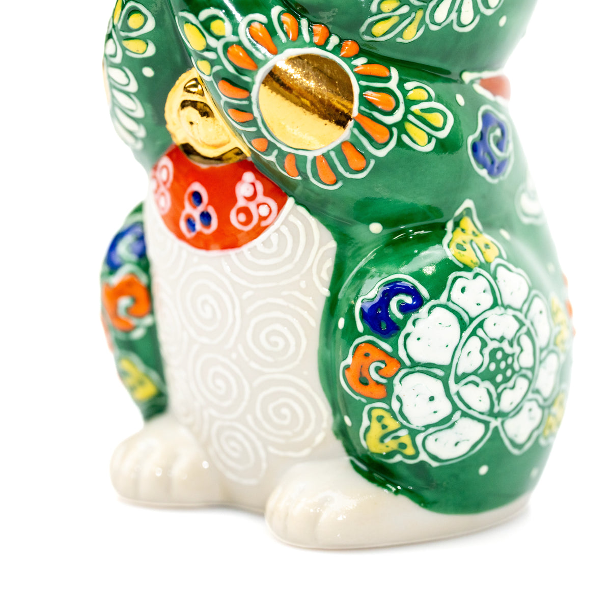 Gold bell, white paws and colorful flowers on the green cat's front.