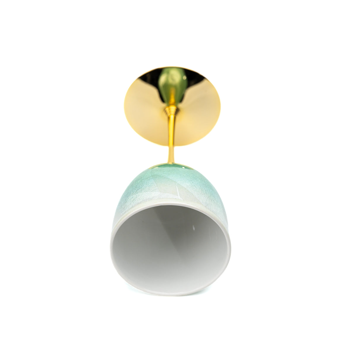 Green Kutani wine cup tilted to show its white interior and underside of the base.