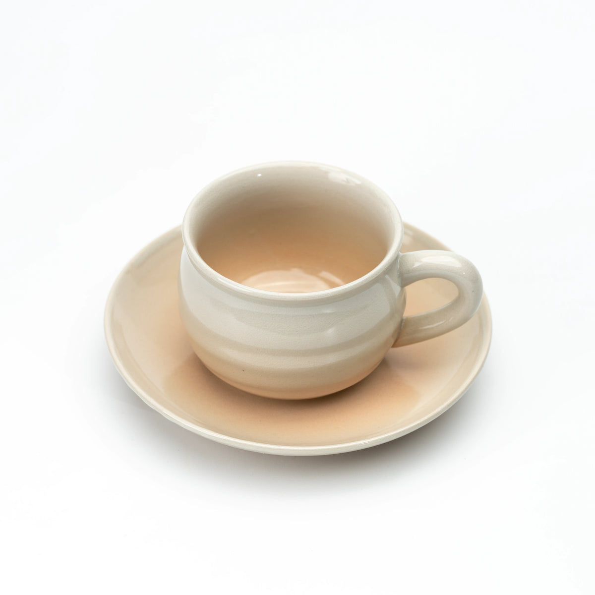 Hagi cup on a matching beige saucer, viewed from above.