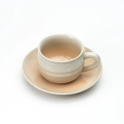 Hagi cup on a matching beige saucer, viewed from above.