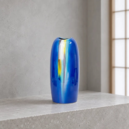 Vase Yusai bleu Hakuho en porcelaine de Kutani, présenté vide sur un rebord en pierre claire, dans une lumière du jour douce et froide.