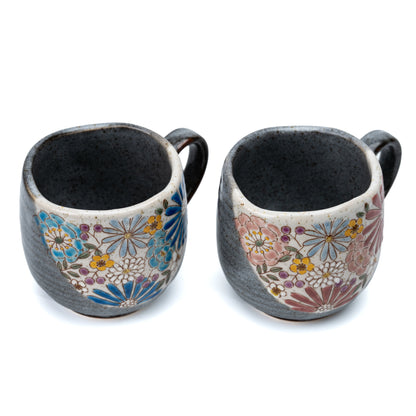 Top view of the red and blue floral Kutani mug pair showing their dark interiors.