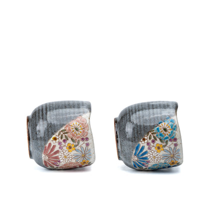 Reverse view of the Kutani mug pair showing gray glaze and floral panel edges.