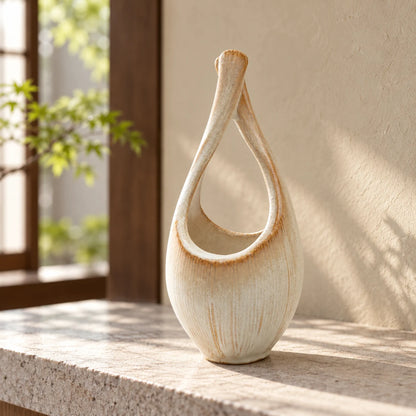 Hechimon Kairo tall cream ceramic vase standing empty on a pale stone ledge in soft morning light.