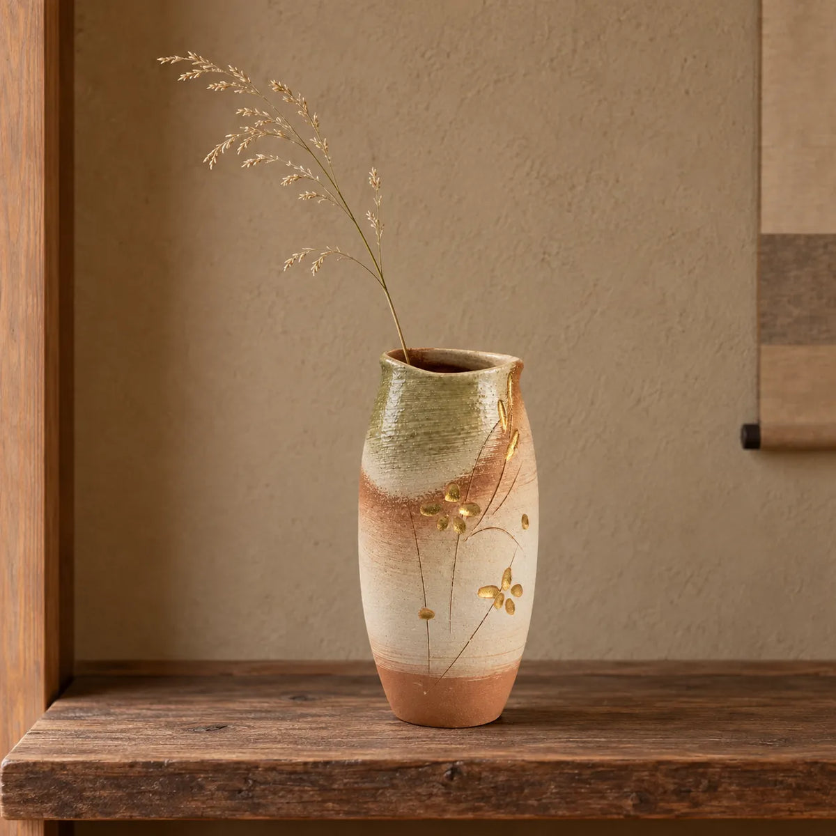 Hechimon Meiyo tall vase holding one light dried grass stem on an aged cedar shelf.