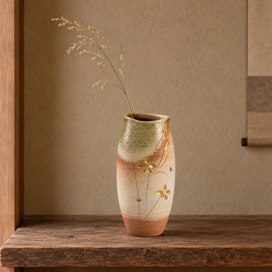 Hechimon Meiyo tall vase holding one light dried grass stem on an aged cedar shelf.