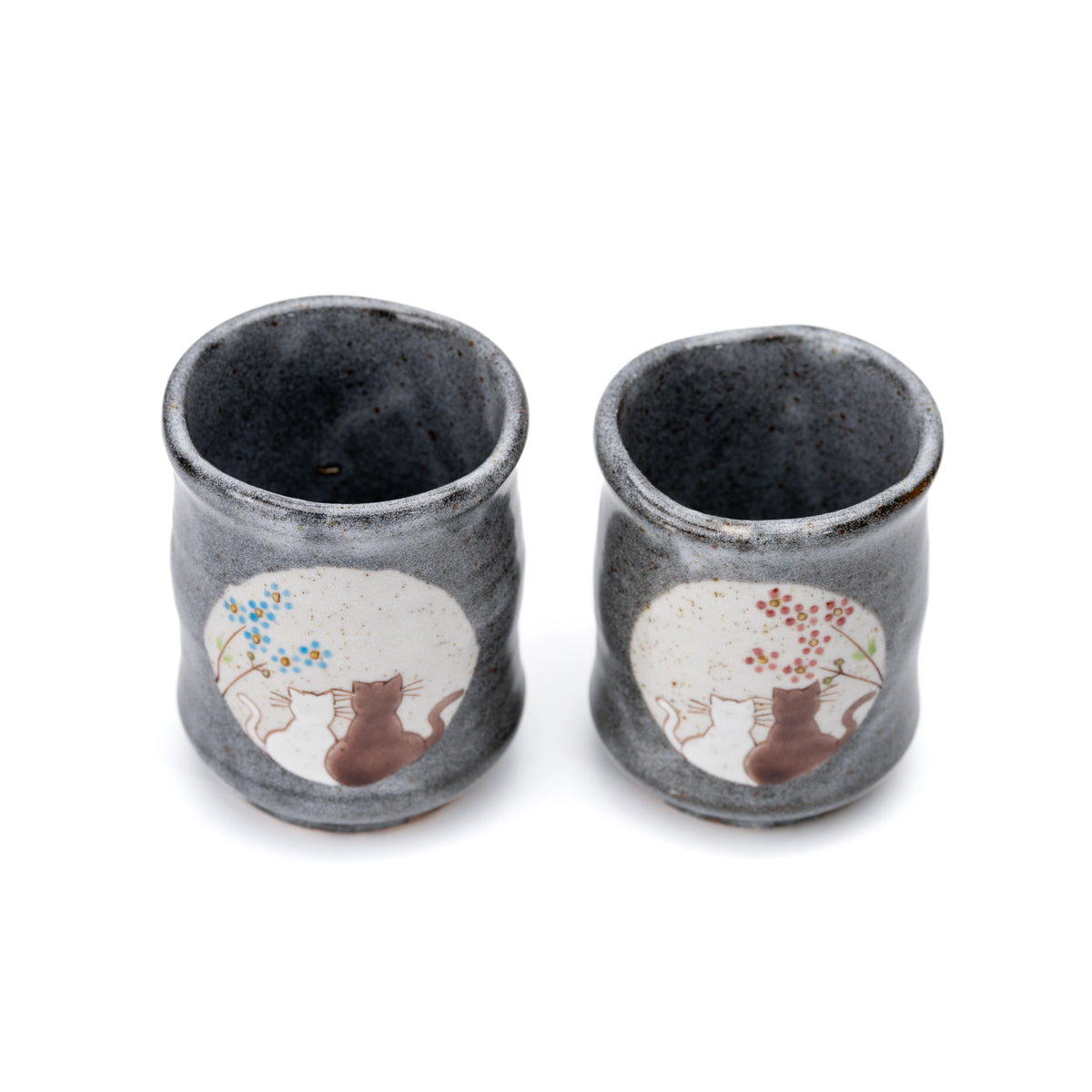 Top view of the Kutani cat yunomi pair showing their dark interiors.