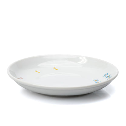 Low side view of the white cat plate and its shallow rim.