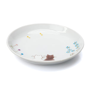 White Kutani plate with two seated cats, small flowers and butterflies on white.