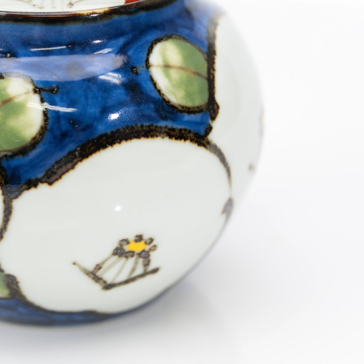 White camellia flower painted across the blue teapot body.