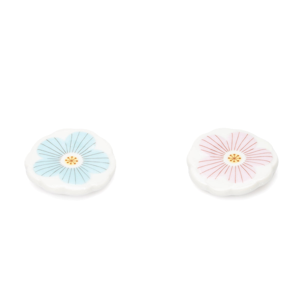 Blue and pink round porcelain chopstick rests with white flower patterns.