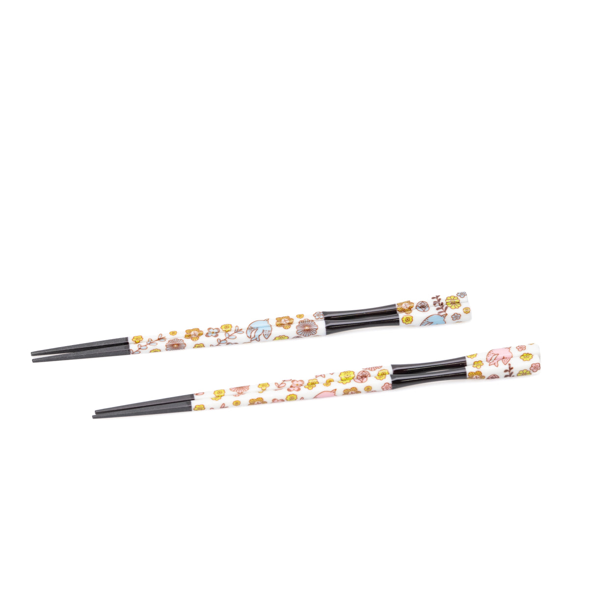 Two pairs of black chopsticks with floral handles arranged on white.