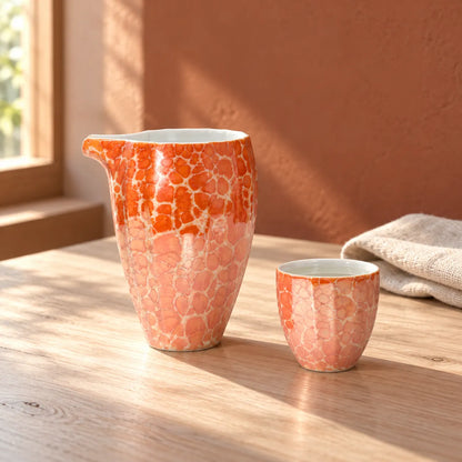 Red Jinpoh Champagne luster katakuchi pourer and matching small sake cup on a sunlit table